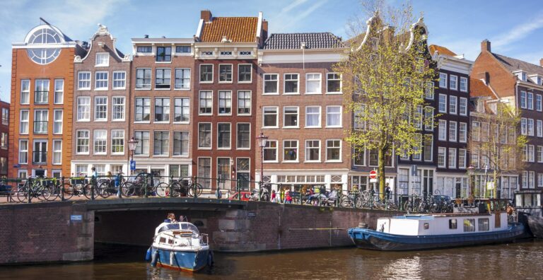 Picturesque view of Amsterdam canal with iconic architecture and boats.