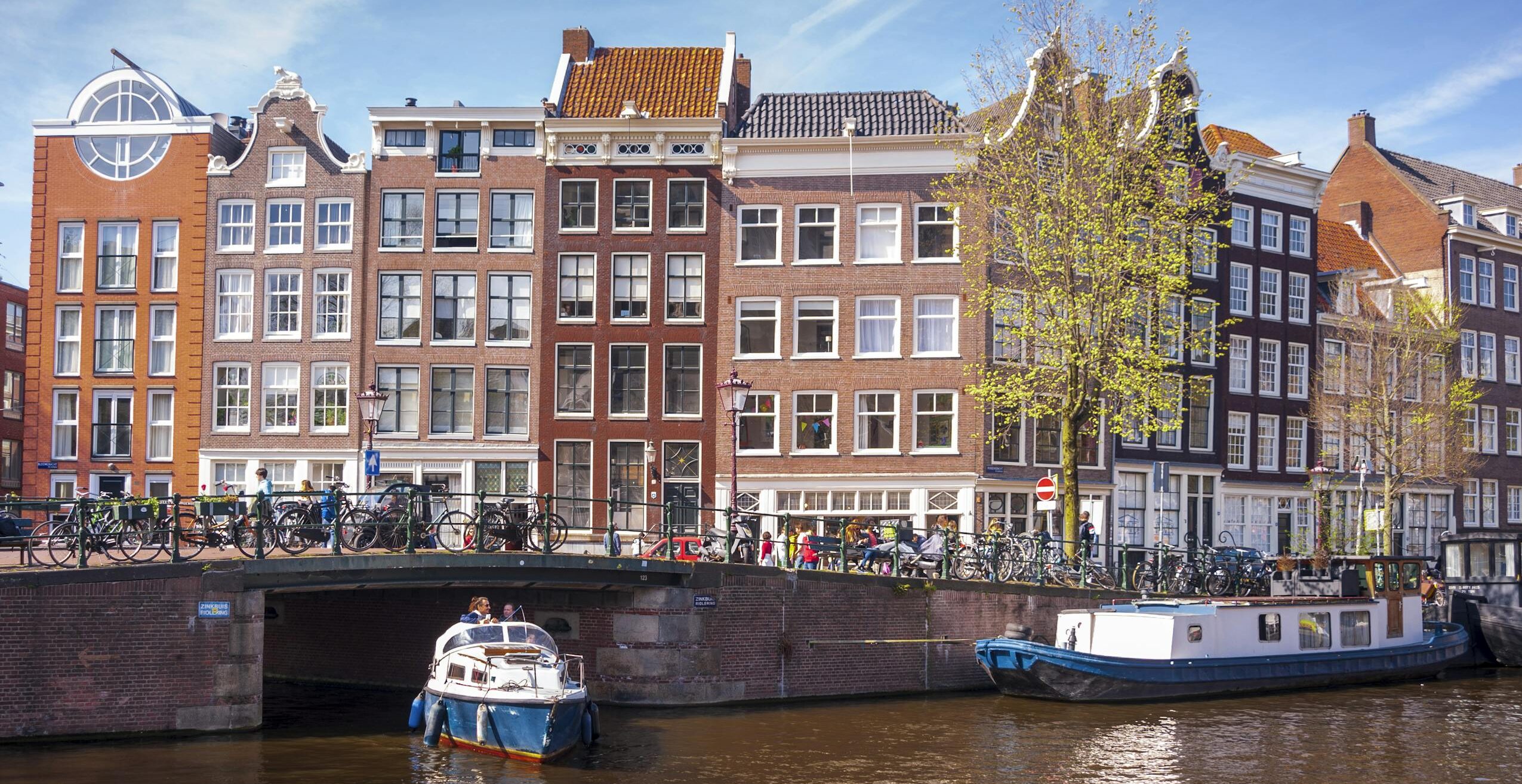 Picturesque view of Amsterdam canal with iconic architecture and boats.